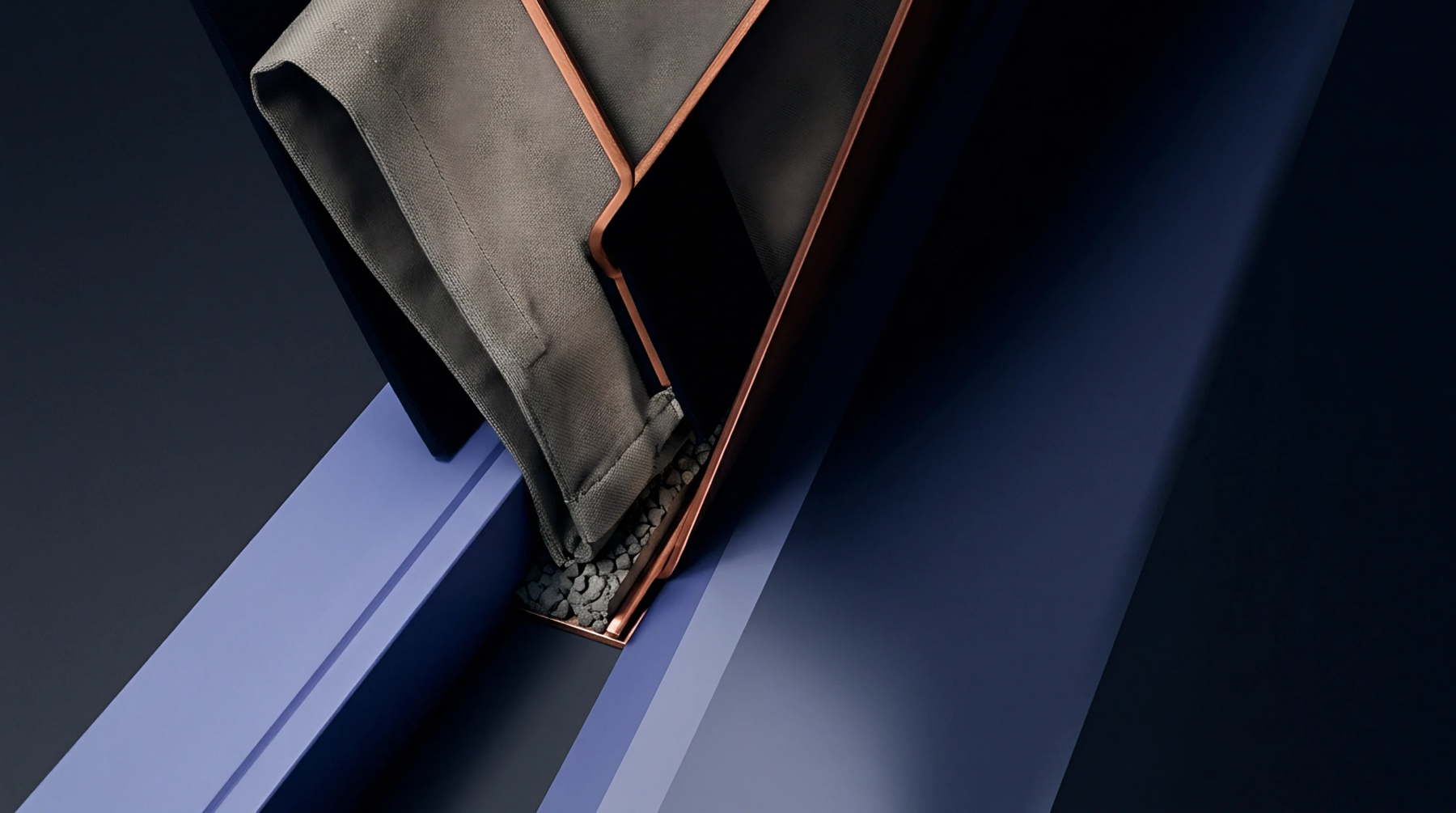 A grey fabric drapes over a dark angular channel filled with dark granular material and edged with copper trim, set against a dark blue background.